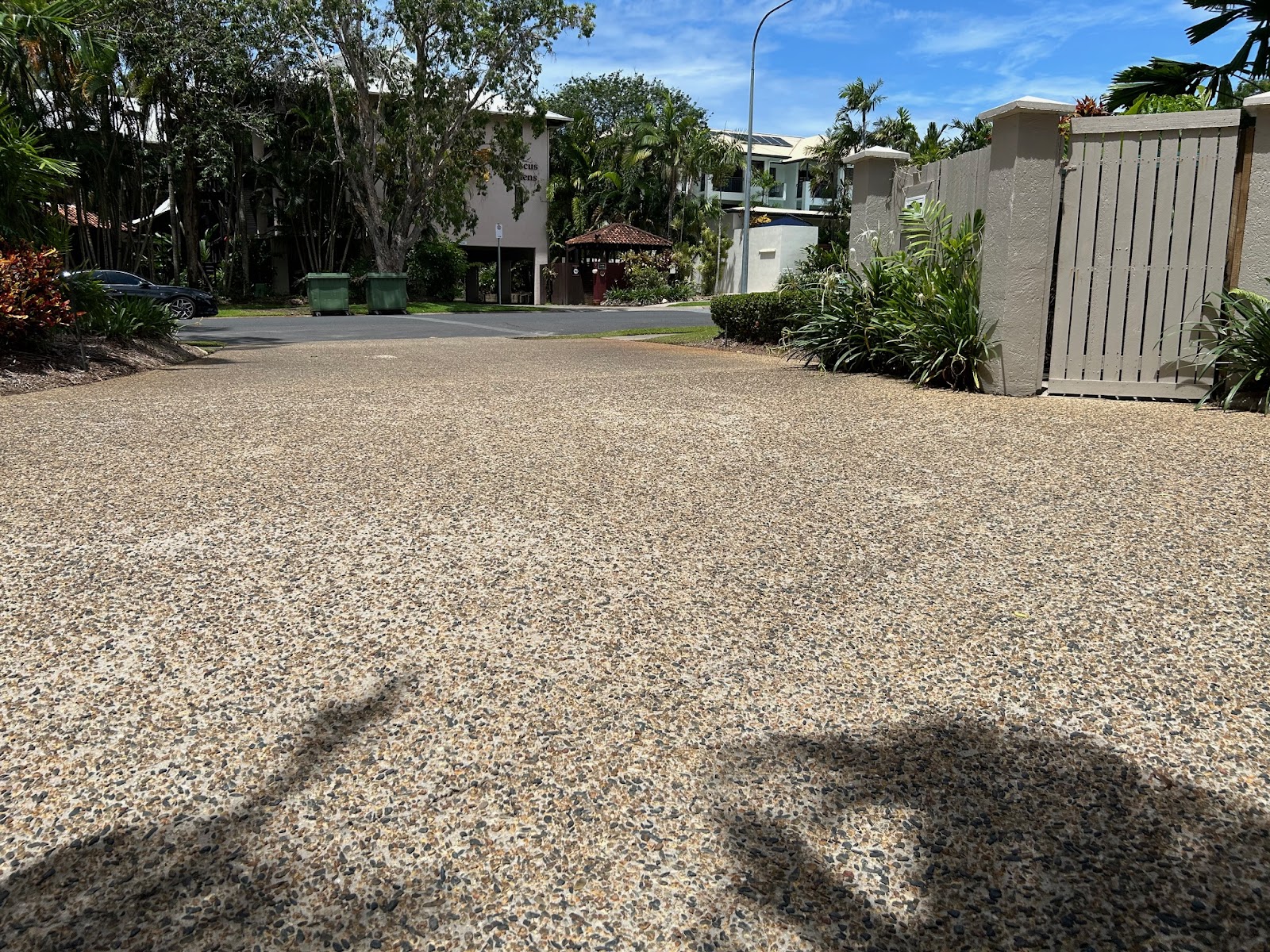A large clean aggregate driveway inside a tropical residential complex